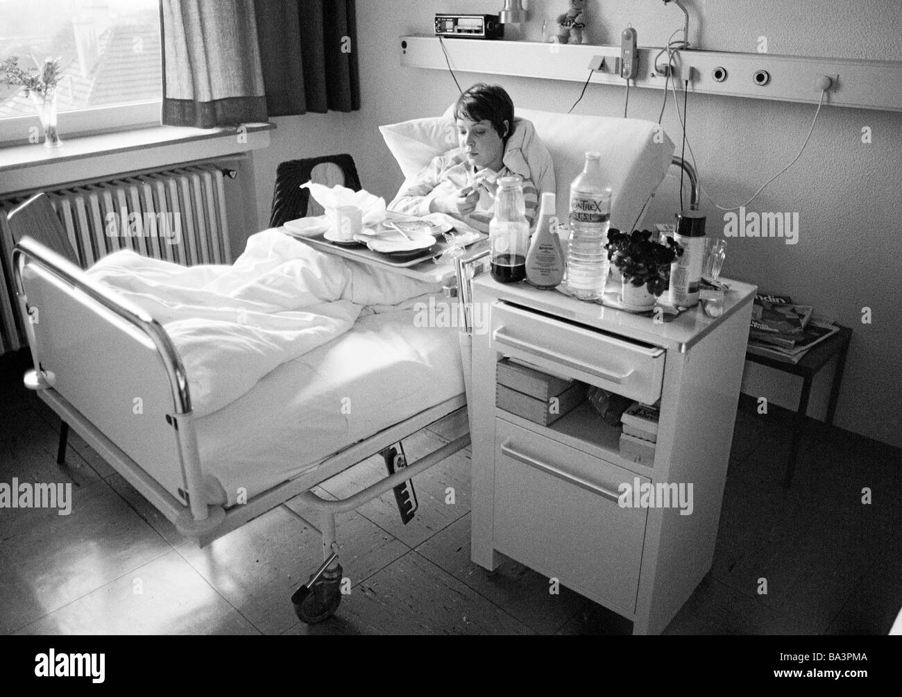 Années 1980, photo en noir et blanc, les gens, la santé, jeune femme dans un hôpital, un dîner dans un lit de malade, âgée de 25 à 30 ans, Monika Banque D'Images