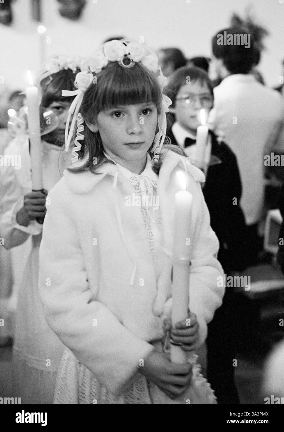 Années 1980, photo en noir et blanc, la religion, le christianisme, la Première Communion, au cours de la procession à l'église les garçons et maintenir la communion des bougies dans la mains, âgés de 8 à 12 ans Banque D'Images