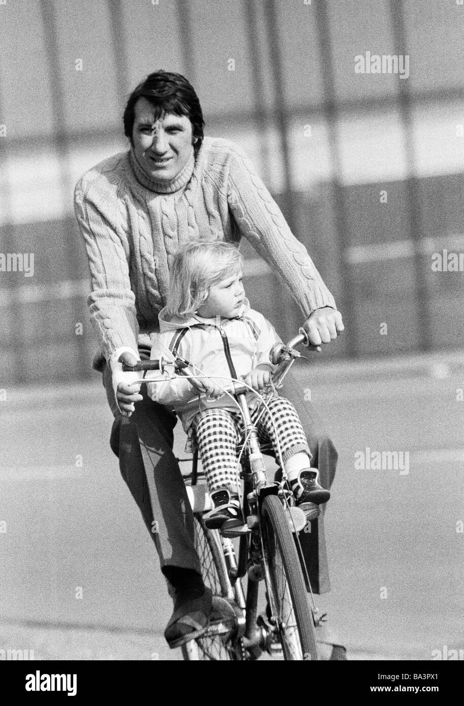 Années 70, photo en noir et blanc, le trafic routier, freetime, jeune homme va sur un voyage en vélo avec sa petite fille, âgée de 25 à 35 ans, de 2 à 4 ans Banque D'Images