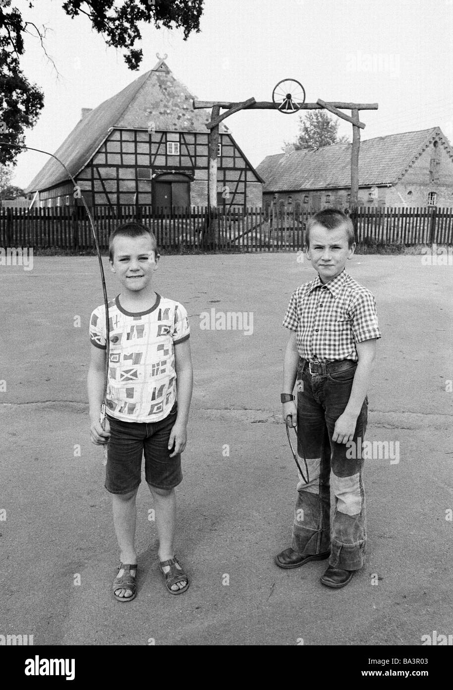 Années 1980, photo en noir et blanc, les gens, les enfants, deux garçons posent devant une ferme à Juergenstorf, âgés de 6 à 10 ans, D-D-Luedersburg-Juergenstorf Luedersburg, commune, Scharnebeck, réserve naturelle Elbufer-Drawehn, Basse-Saxe Banque D'Images