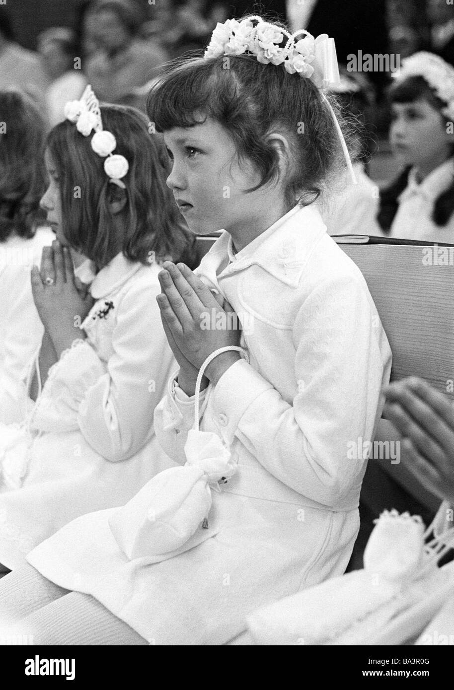 Années 70, photo en noir et blanc, la religion, le christianisme, Première Communion, fille assise dans l'église avec les mains pliées, âgés de 8 à 12 ans, Babette Banque D'Images