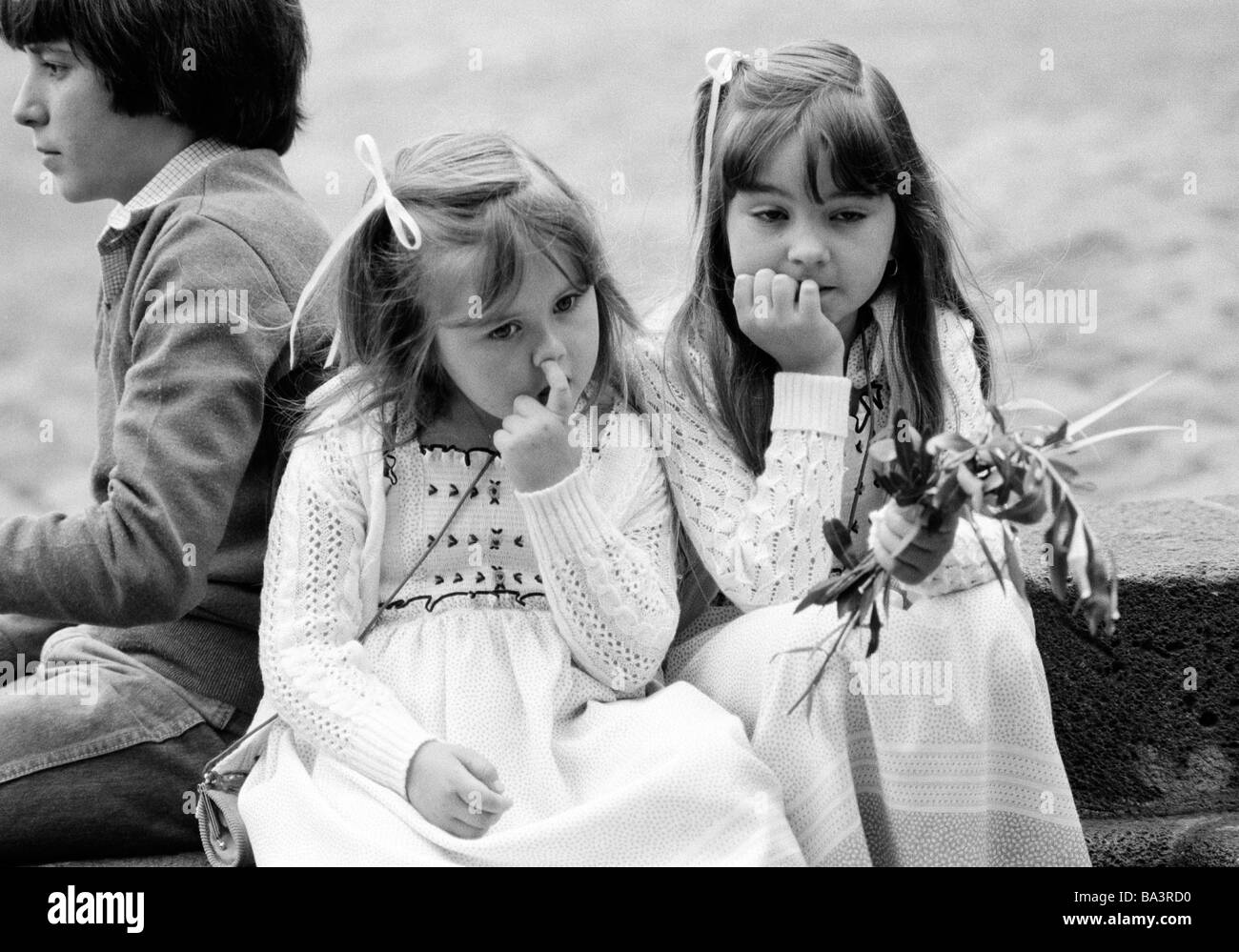 Années 1980, photo en noir et blanc, Pâques, semaine de la passion, dimanche des Rameaux 1981, défilé de l'église, petite fille est titulaire des branches de palmier à la main, une autre fille est assis de côté et prend son nez, âgés de 3 à 5 ans, un garçon est assis derrière, âgés de 10 à 14 ans, l'Espagne, Îles Canaries, Tenerife, La Orotava Banque D'Images