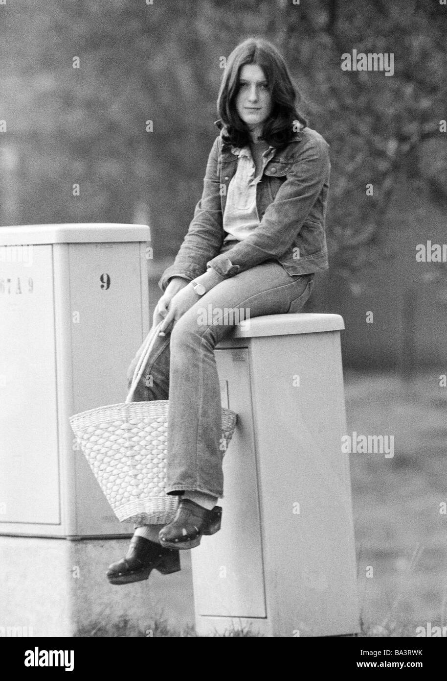 Années 70, photo en noir et blanc, personnage, jeune fille avec un panier siège langoureusement sur une boîte, âgés de 16 à 20 ans Banque D'Images