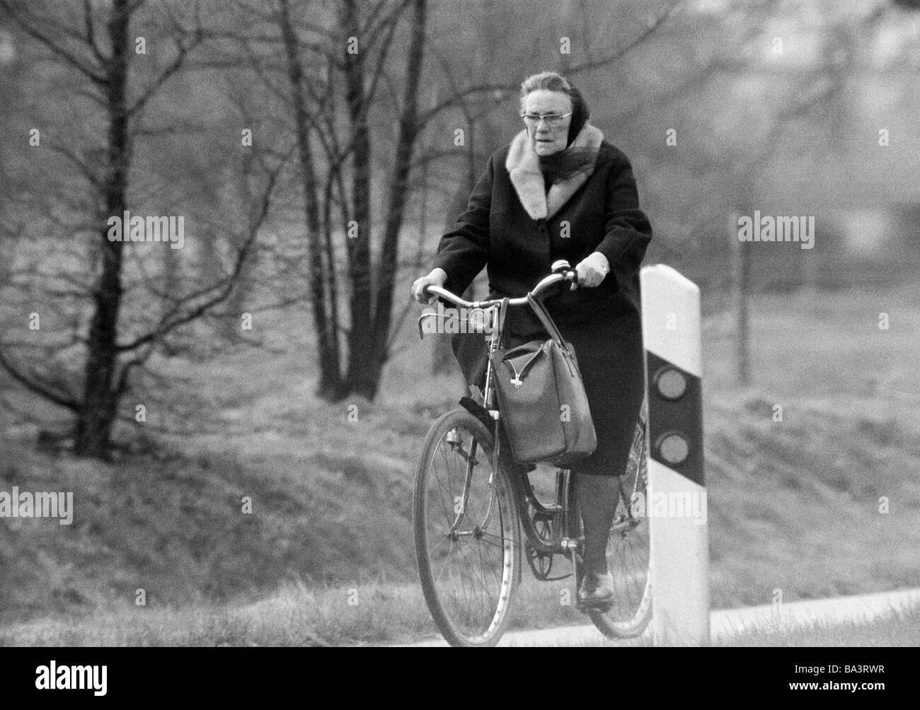 Années 70, photo en noir et blanc, personnage, femme plus âgée conduit un vélo, âgés de 65 à 75 ans Banque D'Images