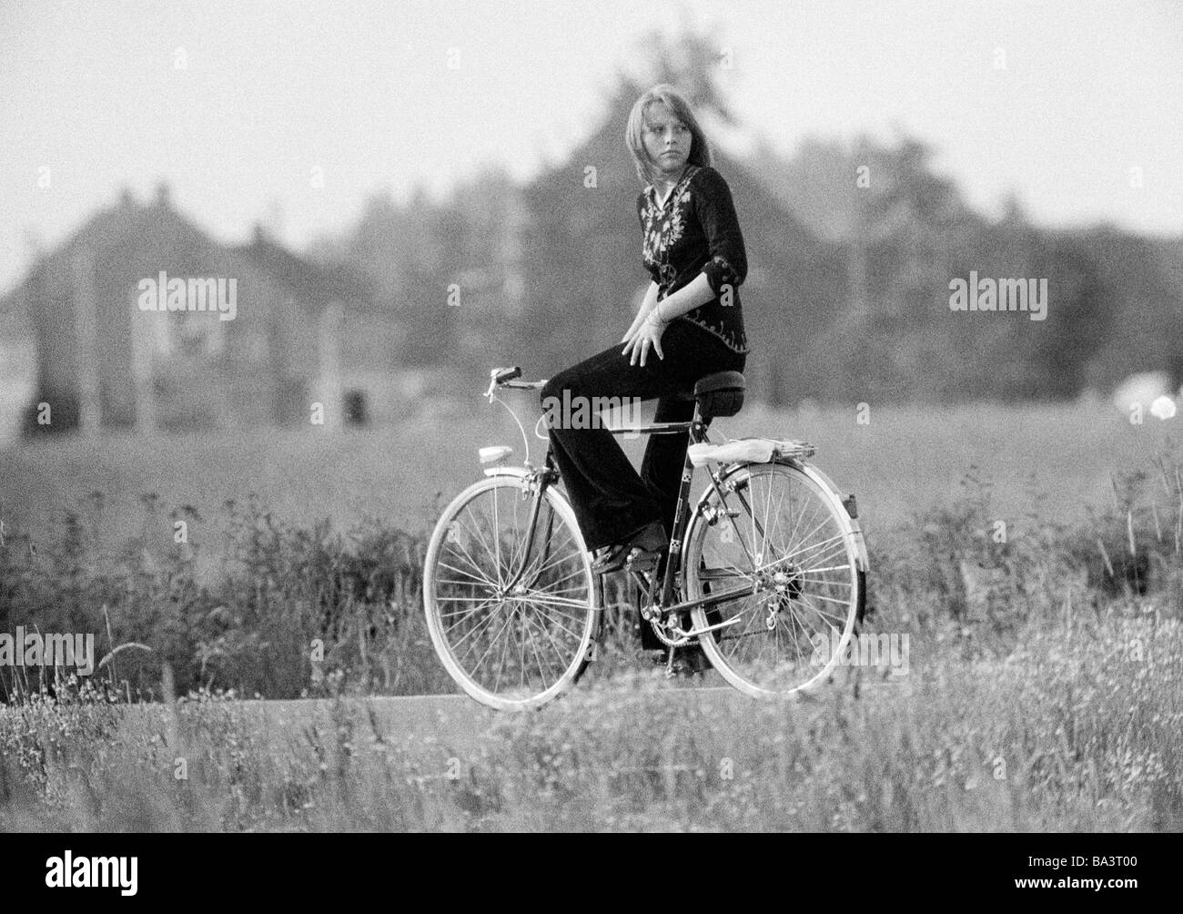 Années 70, photo en noir et blanc, les gens, les jeunes lecteurs de fille un vélo, blouse, pantalon, âgés de 18 à 22 ans Banque D'Images