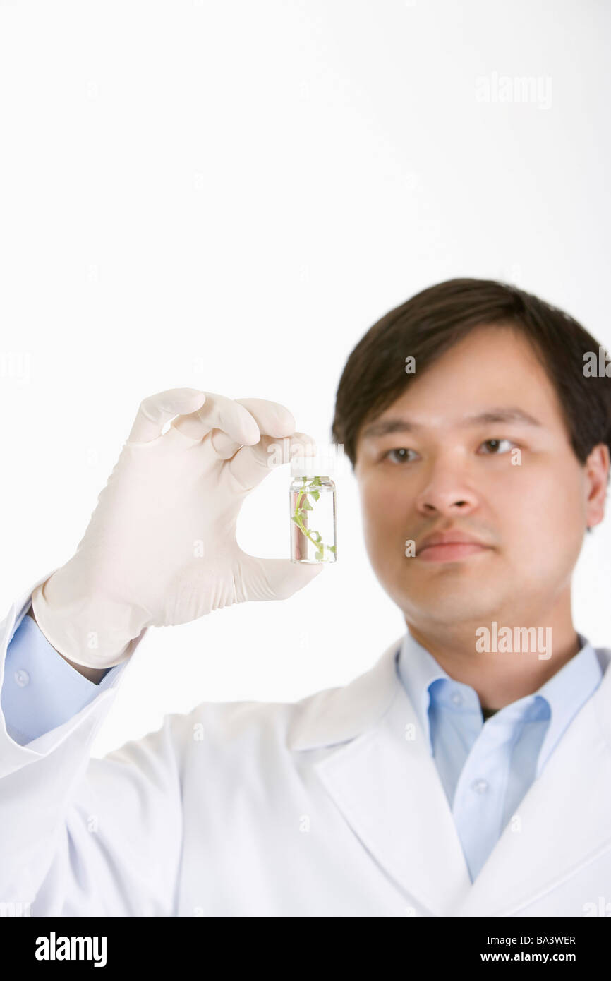 One man in lab coat holding petite bouteille Banque D'Images