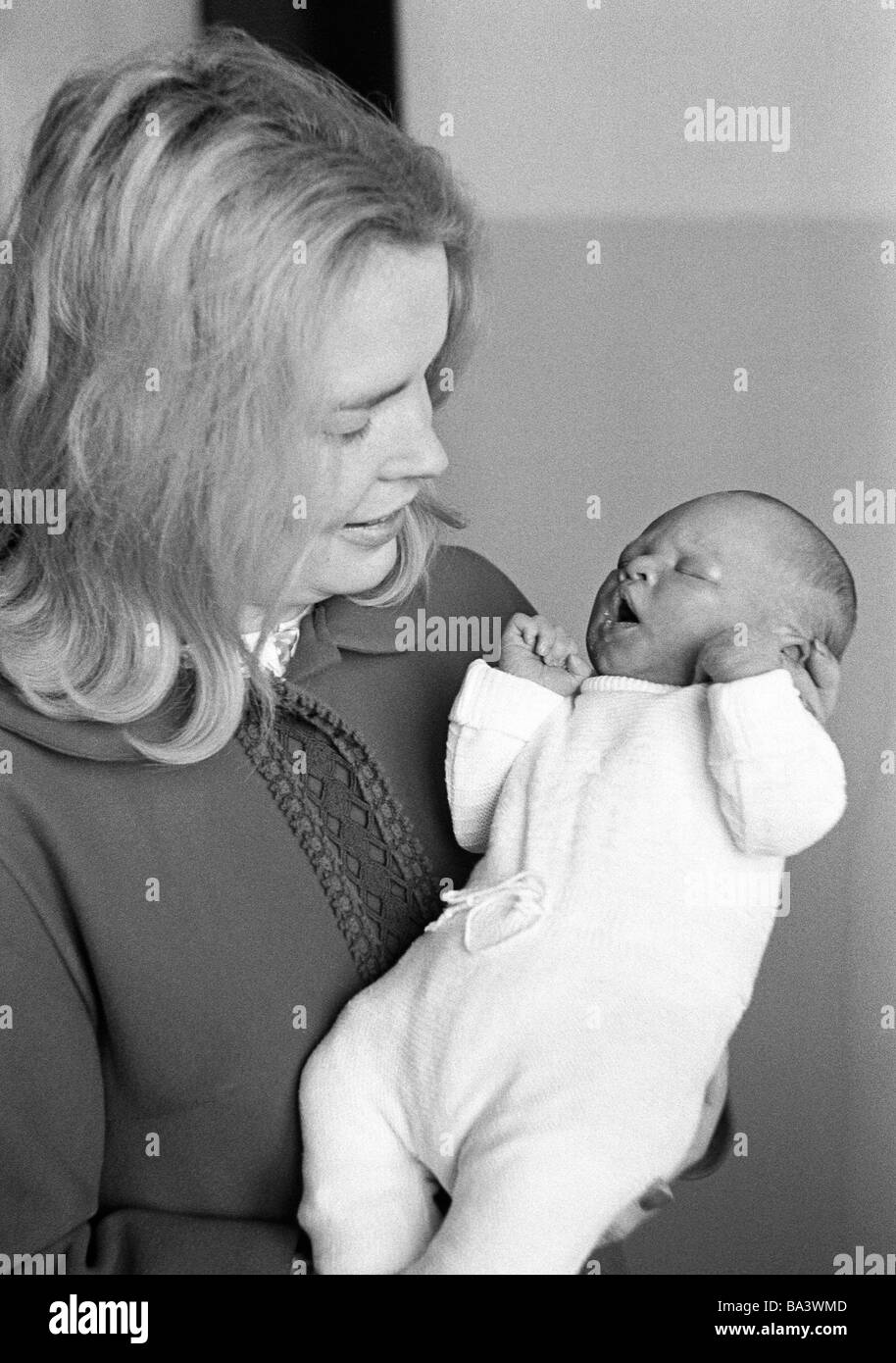 Annees 70 Photo En Noir Et Blanc Les Gens Mere Porte Un Bebe Dans Ses Bras Ages De 25 A 30 Ans Fille Ages De 1 A 2 Semaines Ursula Christina Photo Stock Alamy