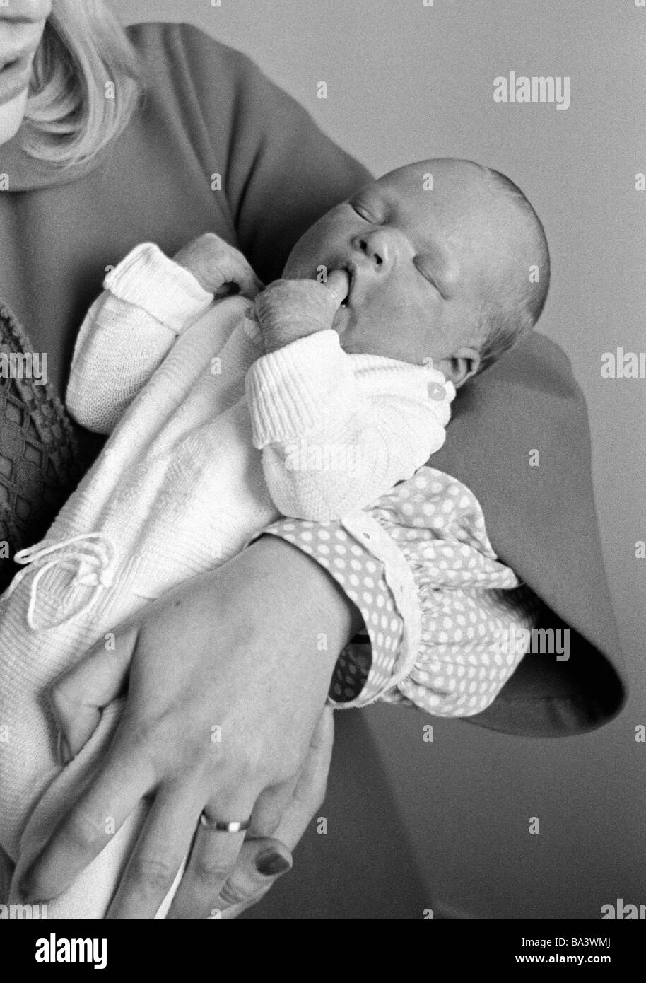Annees 70 Photo En Noir Et Blanc Les Gens Mere Porte Un Bebe Dans Ses Bras Ages De 25 A 30 Ans Fille Ages De 1 A 2 Semaines Ursula Christina Photo Stock Alamy