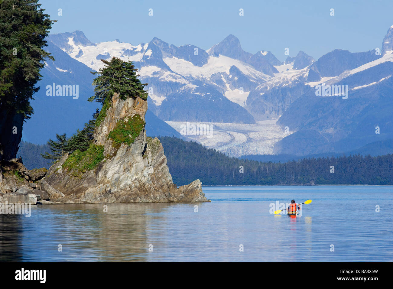 Kayakiste de mer dans la région de Lynn Canal près de côte rocheuse w/Herbert contexte sud-est de l'Alaska Glacier Banque D'Images