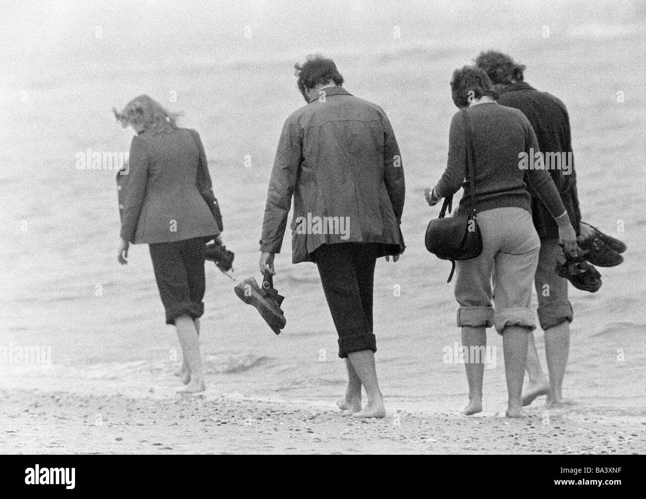 Années 70, photo en noir et blanc, les gens, deux jeunes couples prendre  une excursion de plage, chaussures dans les mains, les pieds nus, âgés de  20 à 30 ans, Mer du