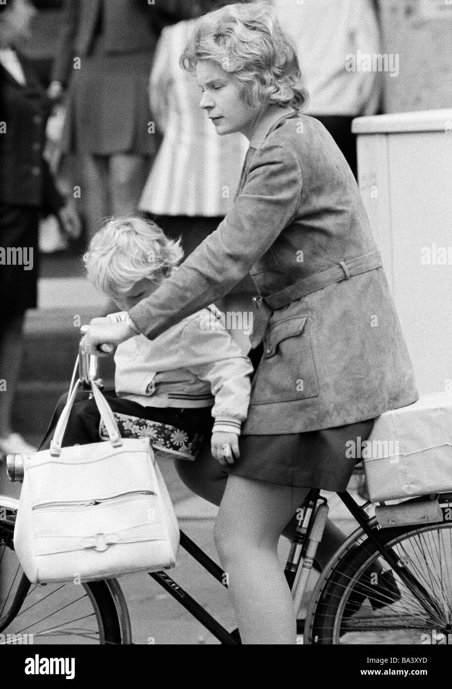 Années 70, photo en noir et blanc, personnage, jeune mère et fille de route sur un vélo, la fille se trouve dans le siège pour enfants, colis sur le pannier rack, âgés de 25 à 35 ans, de 3 à 5 ans Banque D'Images
