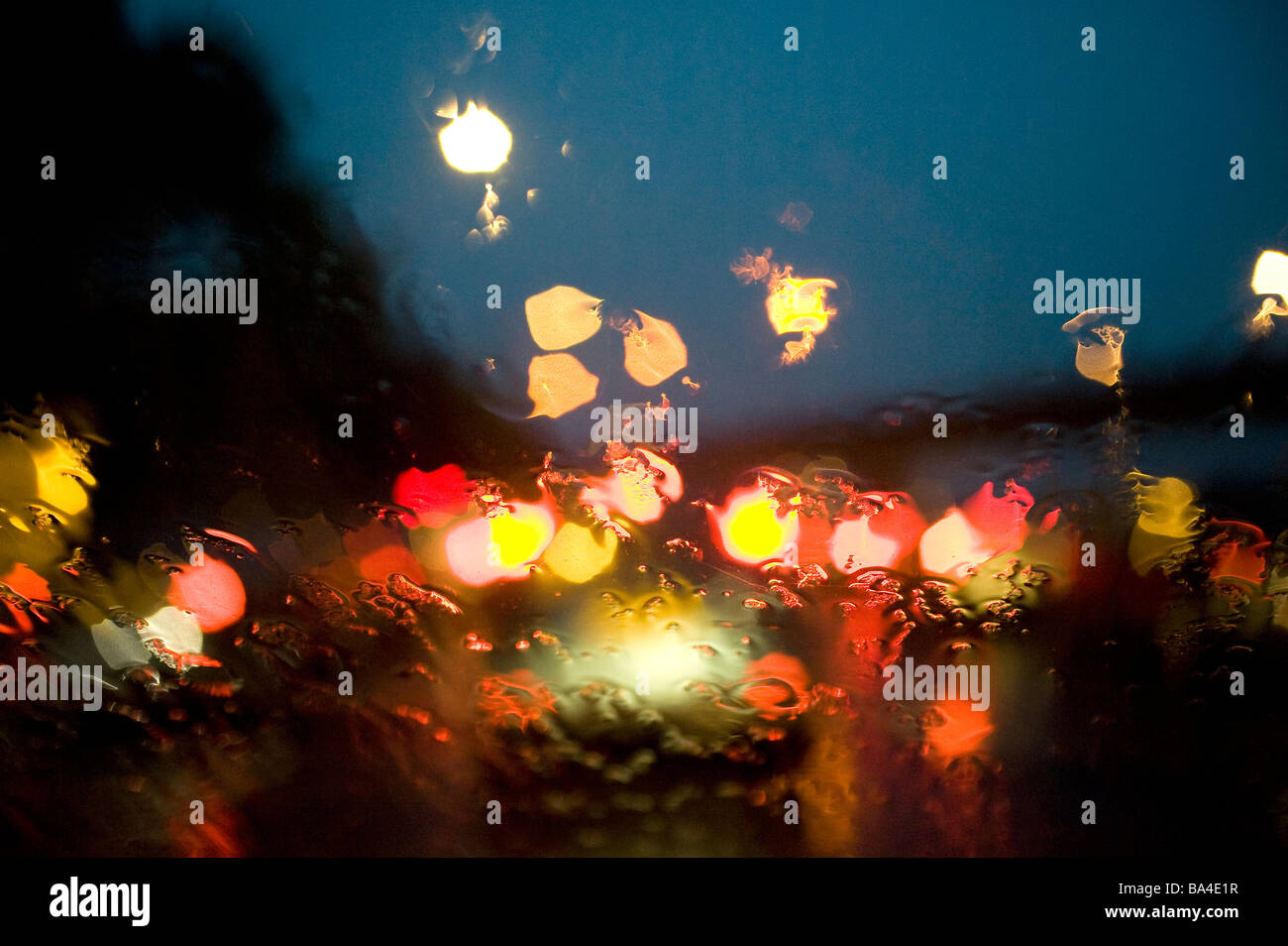 Vue des pilotes à travers un pare-brise couvert pluie d'attente de circulation sur une pluie d'autoroute pendant l'heure de pointe du soir Banque D'Images