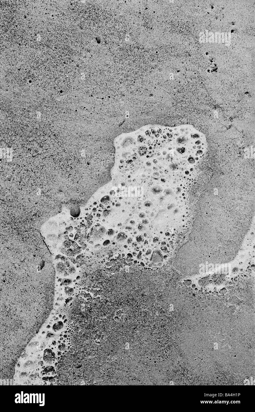 Plage de sable de mousse humide sec s/w plage de Meereswellen überspülen eau rives-surf surf-vie tranquillement de mousse foam close-up Banque D'Images