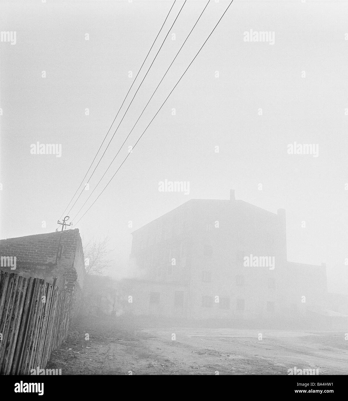 La Lituanie Klaipeda house fence power lines le brouillard s/w Memel yard-bois résidence bâtiments clôture lignes téléphoniques vide sombre brouillard Banque D'Images