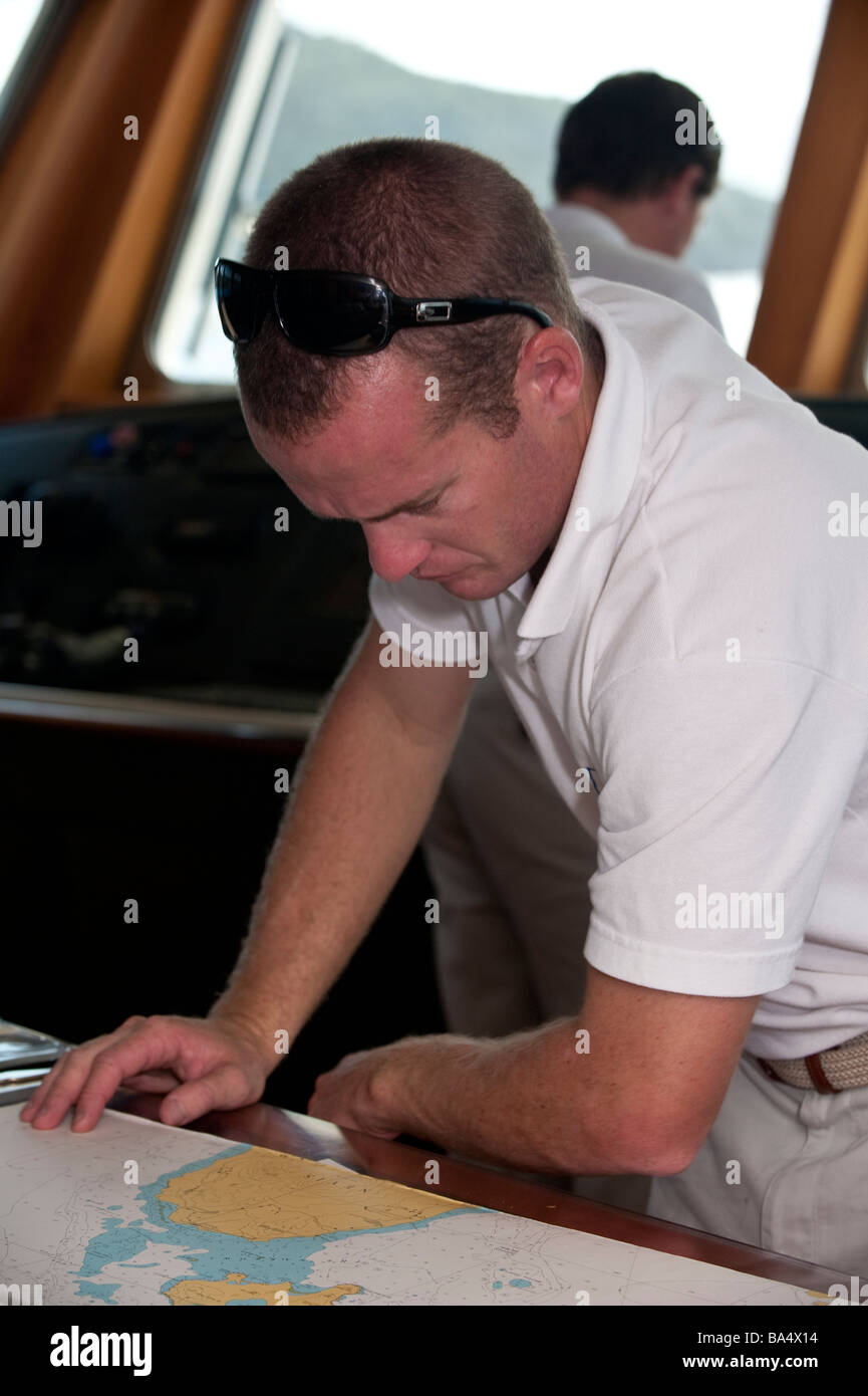 L'agent en chef l'étude le tableau de Nevis dans les Caraïbes à la table à cartes à bord super yacht 'Big Aron' Banque D'Images