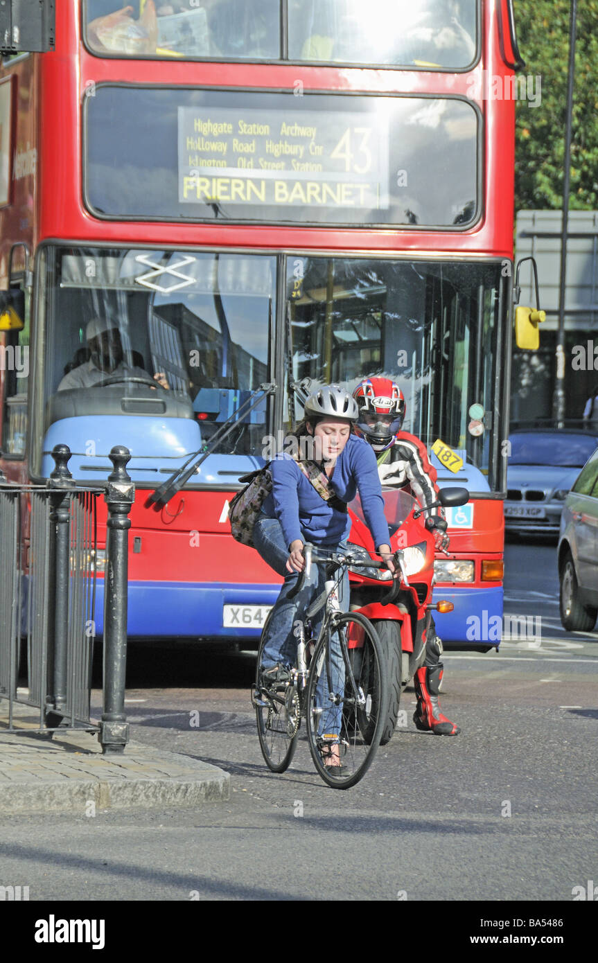 Cycliste féminine en face de bus Angel Islington Londres Angleterre Royaume-uni Banque D'Images
