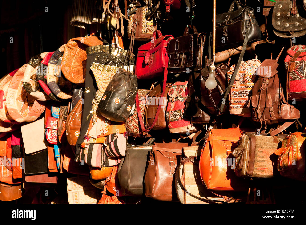 Sélection de divers modèles de sacs en cuir fait main traditionnel sur l'affichage dans la soirée soleil dans les souks de Marrakech Banque D'Images