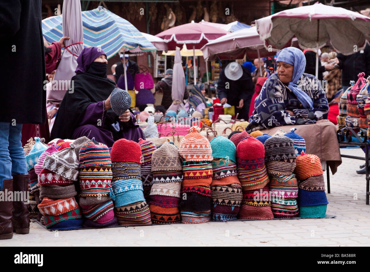 Les femmes arabes locaux offrent des chapeaux colorés faits-main pour la  vente aux touristes dans la Medina, Marrakech Photo Stock - Alamy