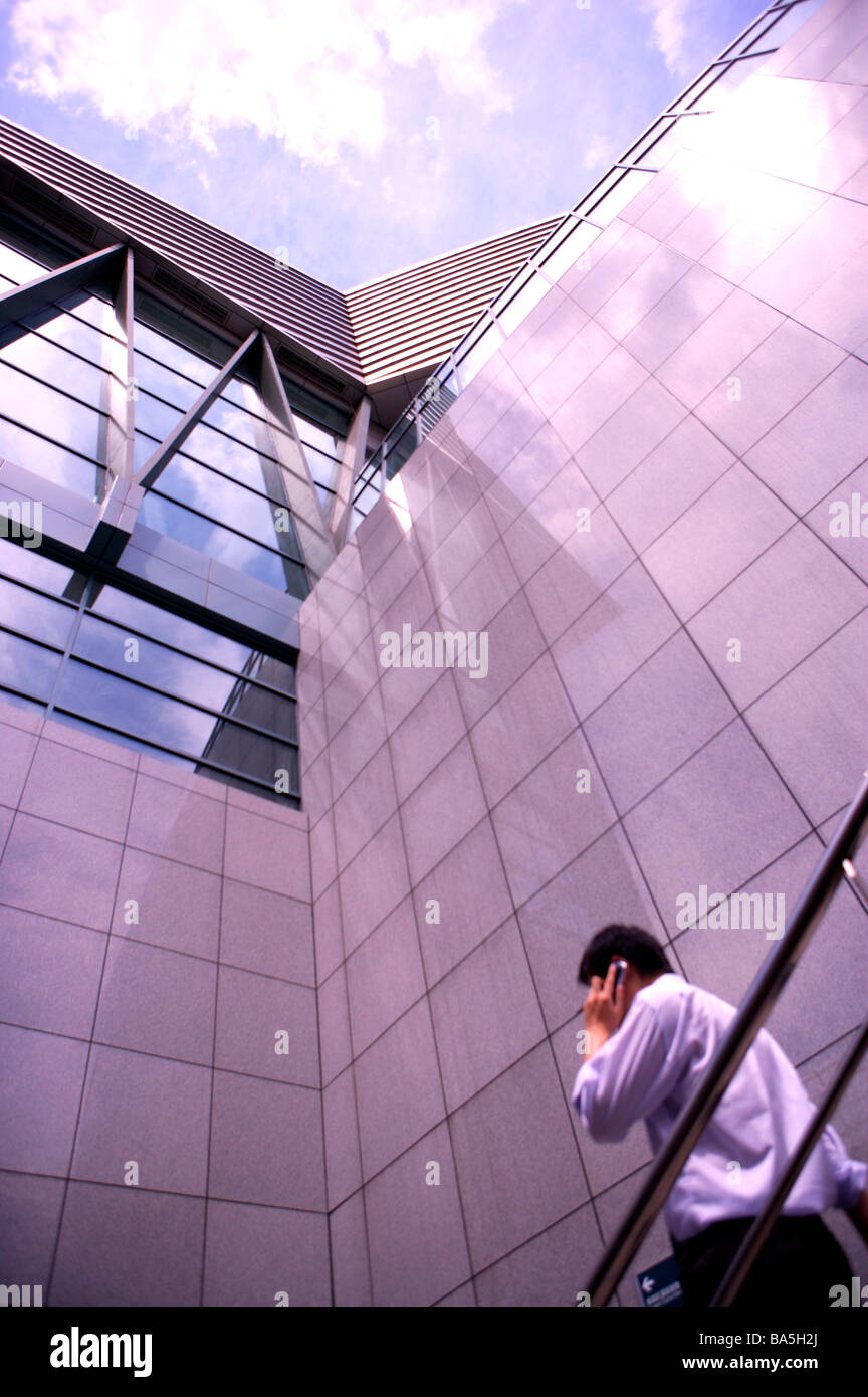 Businessman walking down stairs using cell phone low angle view Banque D'Images