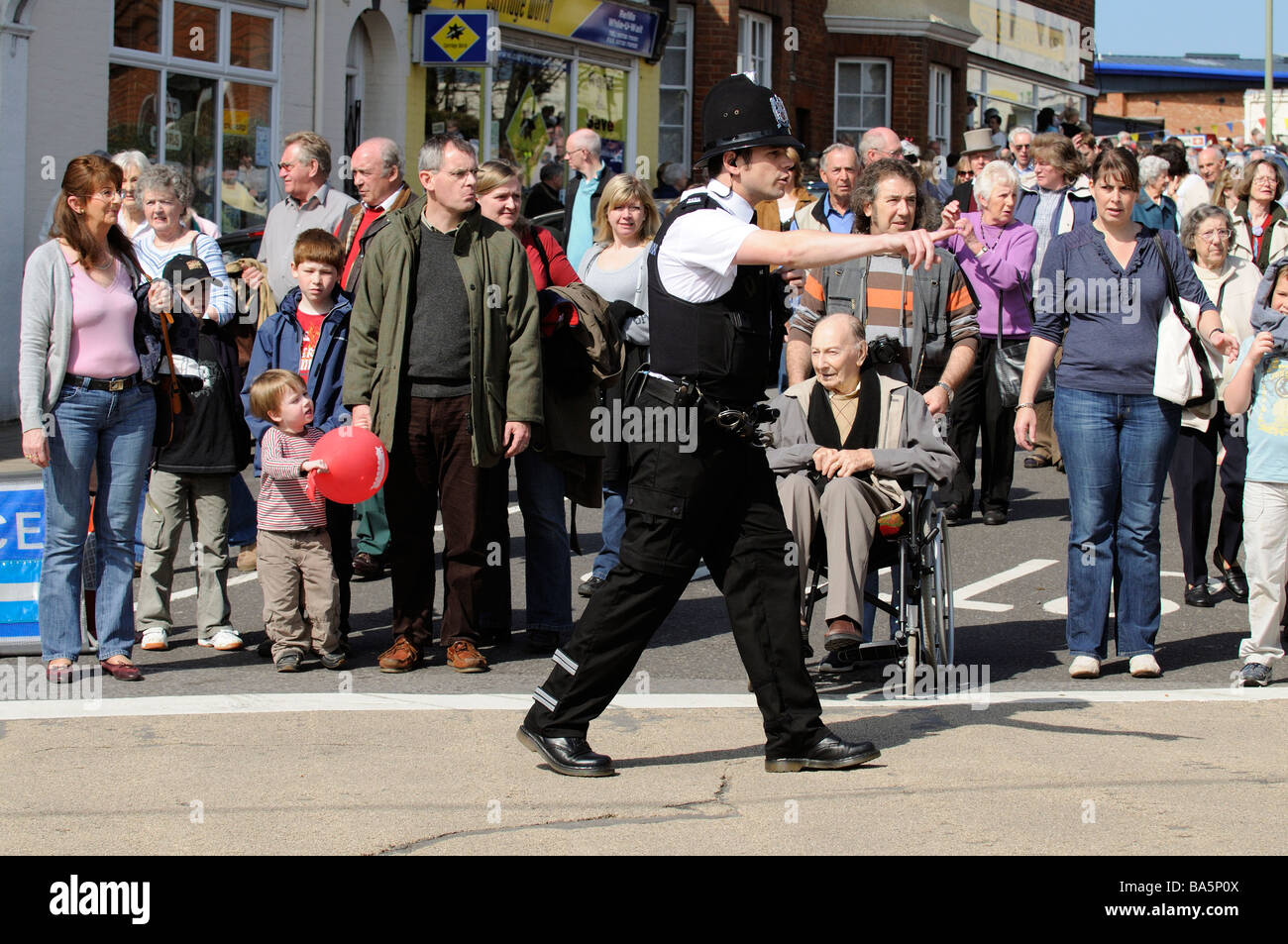 Policier en devoir de contrôle de la circulation et la foule dans le centre-ville de Petersfield Hampshire England UK Banque D'Images