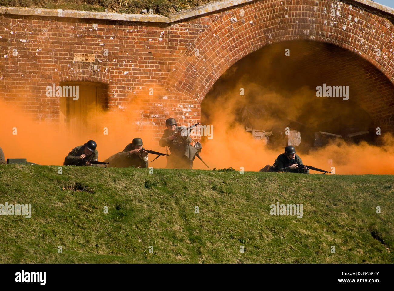WW2 soldats allemands en scène de bataille avec écran de fumée orange.événement reconstitution Fort Nelson Banque D'Images