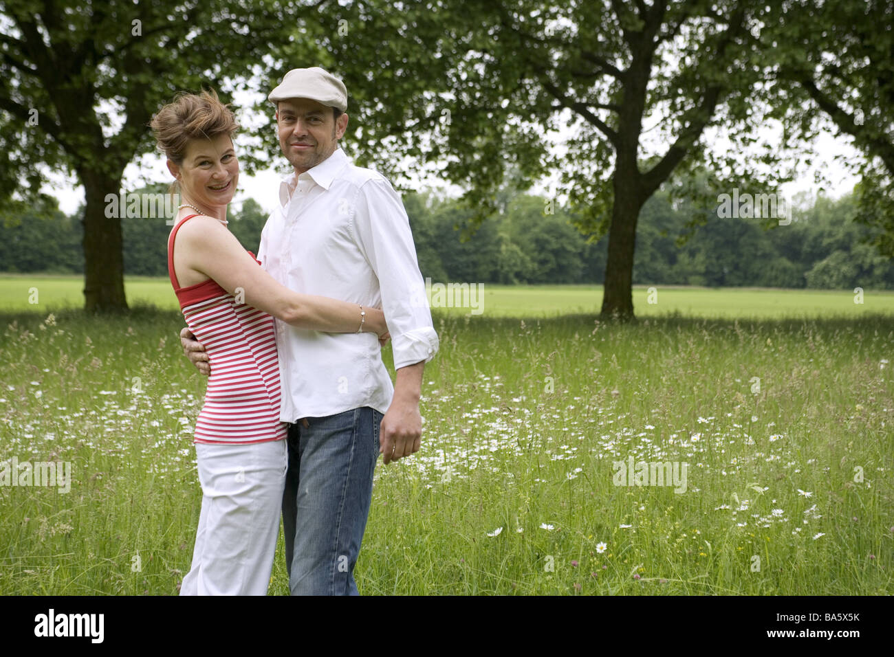 Paire parc tombe amoureux embrasser gaiement les gens aiment la série détails paire de 30-40 ans caméra regard sourit joyeusement la joie l'amour Banque D'Images