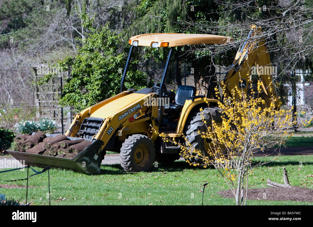 Un tracteur jaune avec une benne de chargement de gazon fraîchement coupé. Banque D'Images