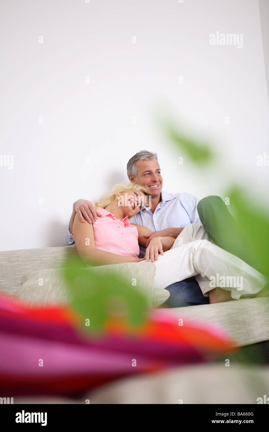 Salles de séjour canapé caresser joyeusement paire flou de l'usine de personnes 30-40 ans 40-50 ans partenariat relation Banque D'Images