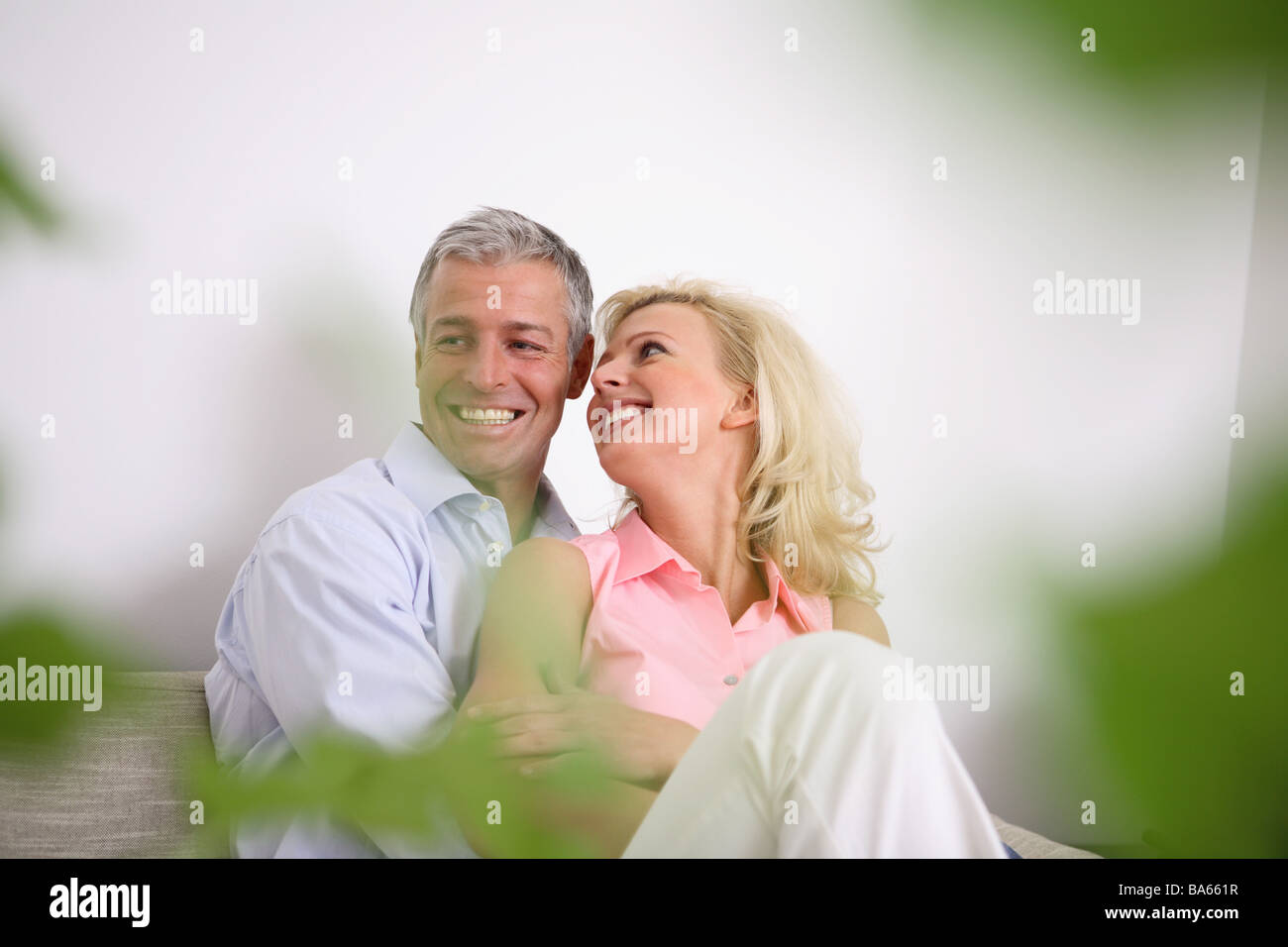 Salles de séjour canapé caresser joyeusement paire plante série portrait flou personnes 30-40 ans 40-50 ans smiles fun tombe amoureux Banque D'Images