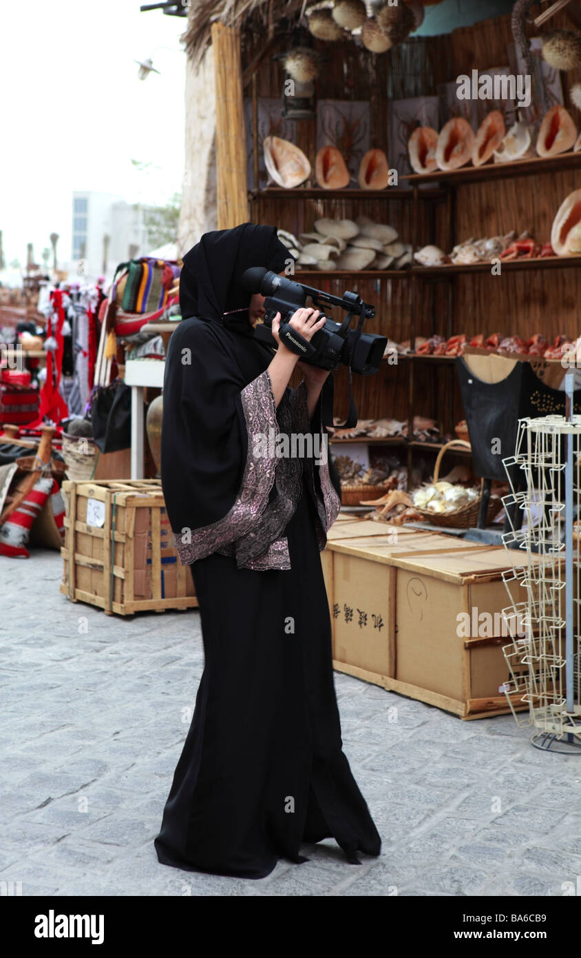 Une jeune femme musulmane Qatari la réalisation d'une vidéo de Souq Waqif Doha Banque D'Images