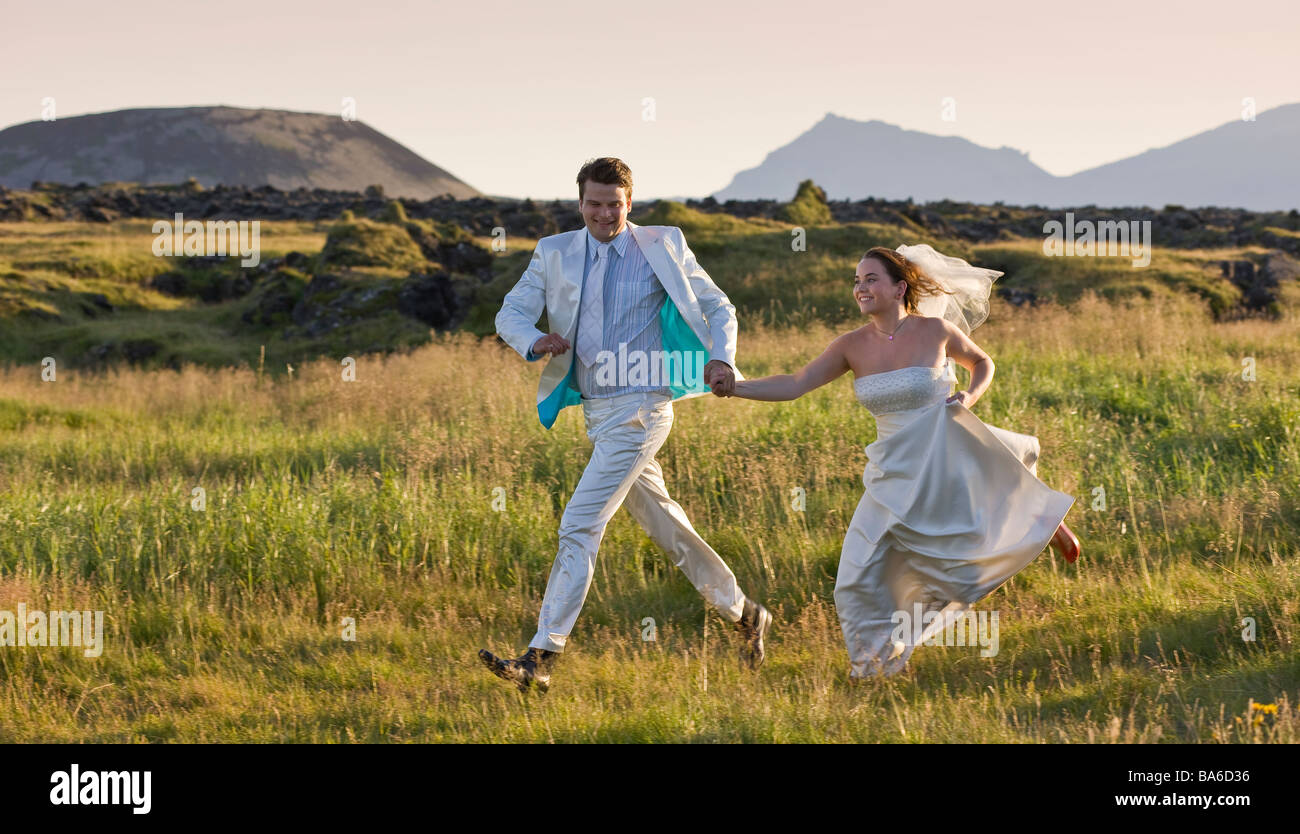 Wedding couple fonctionnant en campagne, à l'Islande de l'ouest de la péninsule de Snæfellsnes Banque D'Images