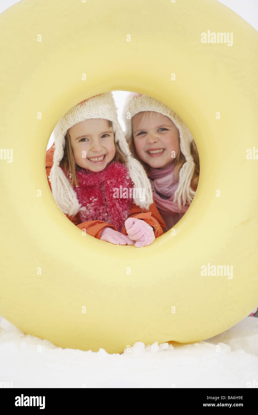 Deux enfants fun" examine les pneus neige luges filles 4-6 ans frères soeurs amis à l'extérieur en caoutchouc pneus hivers- Banque D'Images