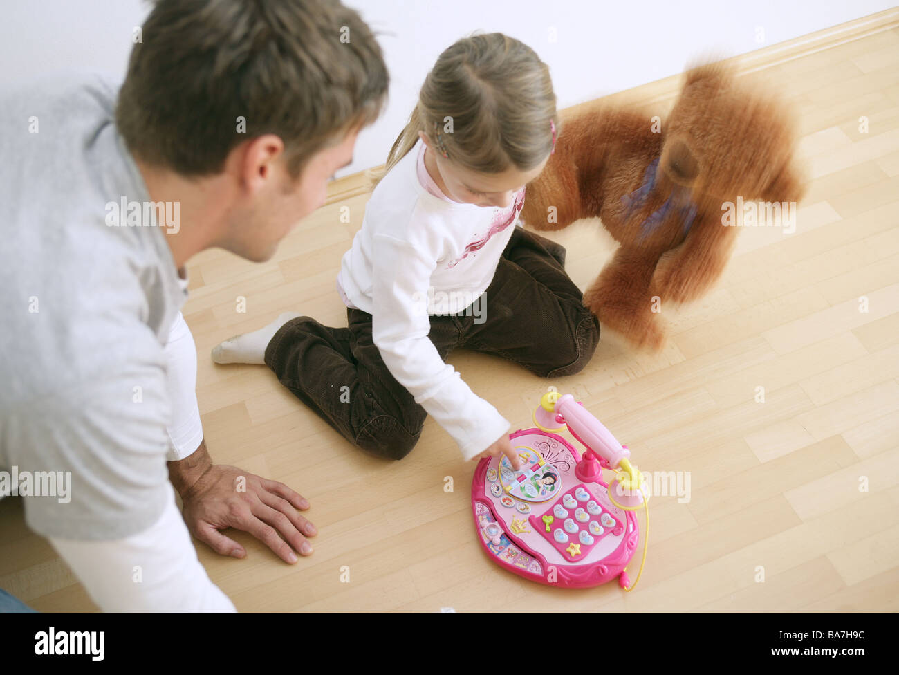 Père et fille (3-4 ans) à jouer avec un jouet téléphone et un ours en peluche, Munich, Allemagne Banque D'Images