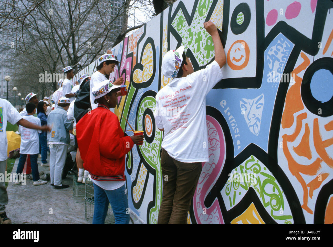 Les adolescents à l'école de peinture murale dans le cadre du programme d'art dans les chiffres tirés d'ici la fin de l'artiste Keith Haring à Grant Park Chicago Illinois Banque D'Images
