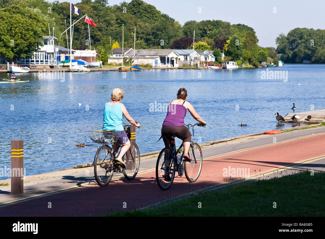 Les cyclistes de sexe féminin profitez de la vue sur la rivière de la Thames Path Cycle de quelques centaines de mètres en aval du pont de Kingston Banque D'Images