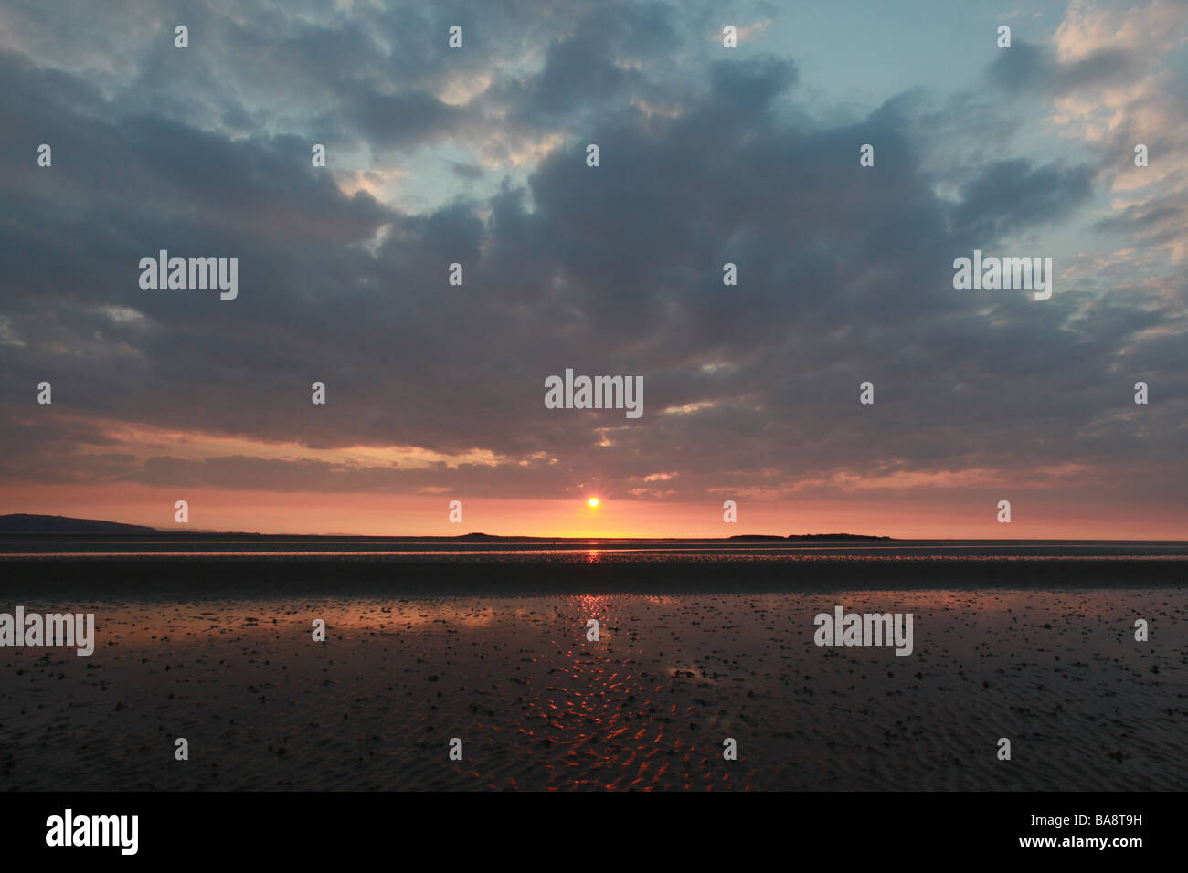 Plus de coucher de soleil spectaculaire île Hilbre et les collines galloises. Banque D'Images