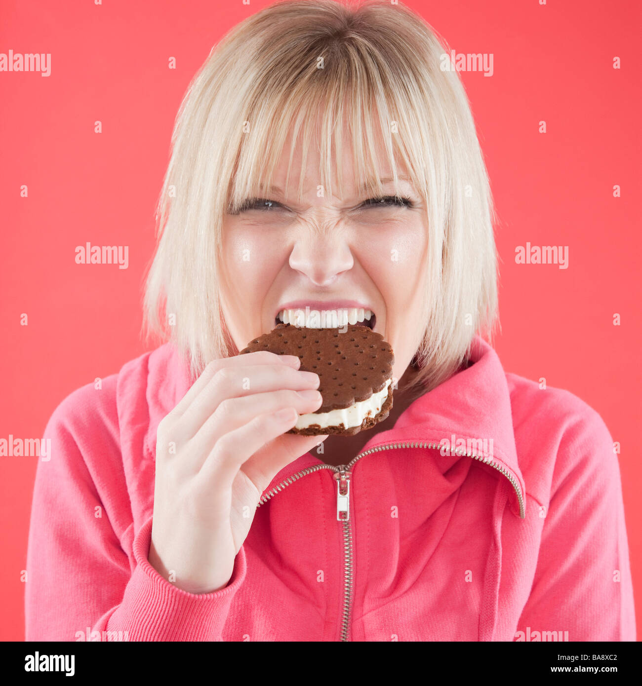 Woman eating ice cream sandwich Banque D'Images