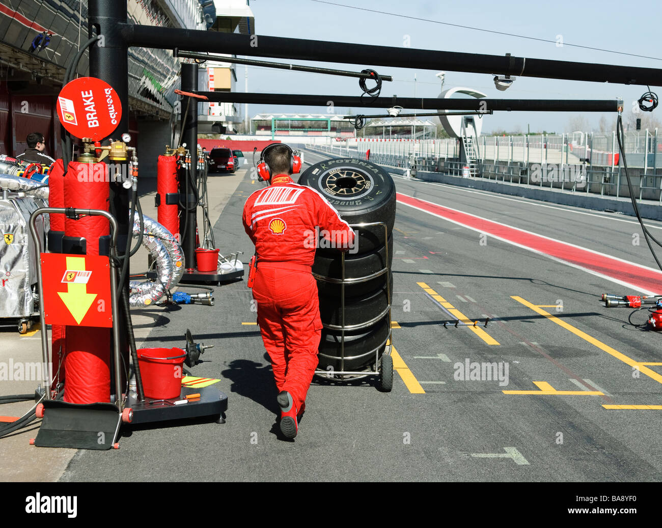 Puhes mécanicien Ferrari pile de pneus de course le long de voie des stands à racetrack à la formule 1 séances d'essai Banque D'Images