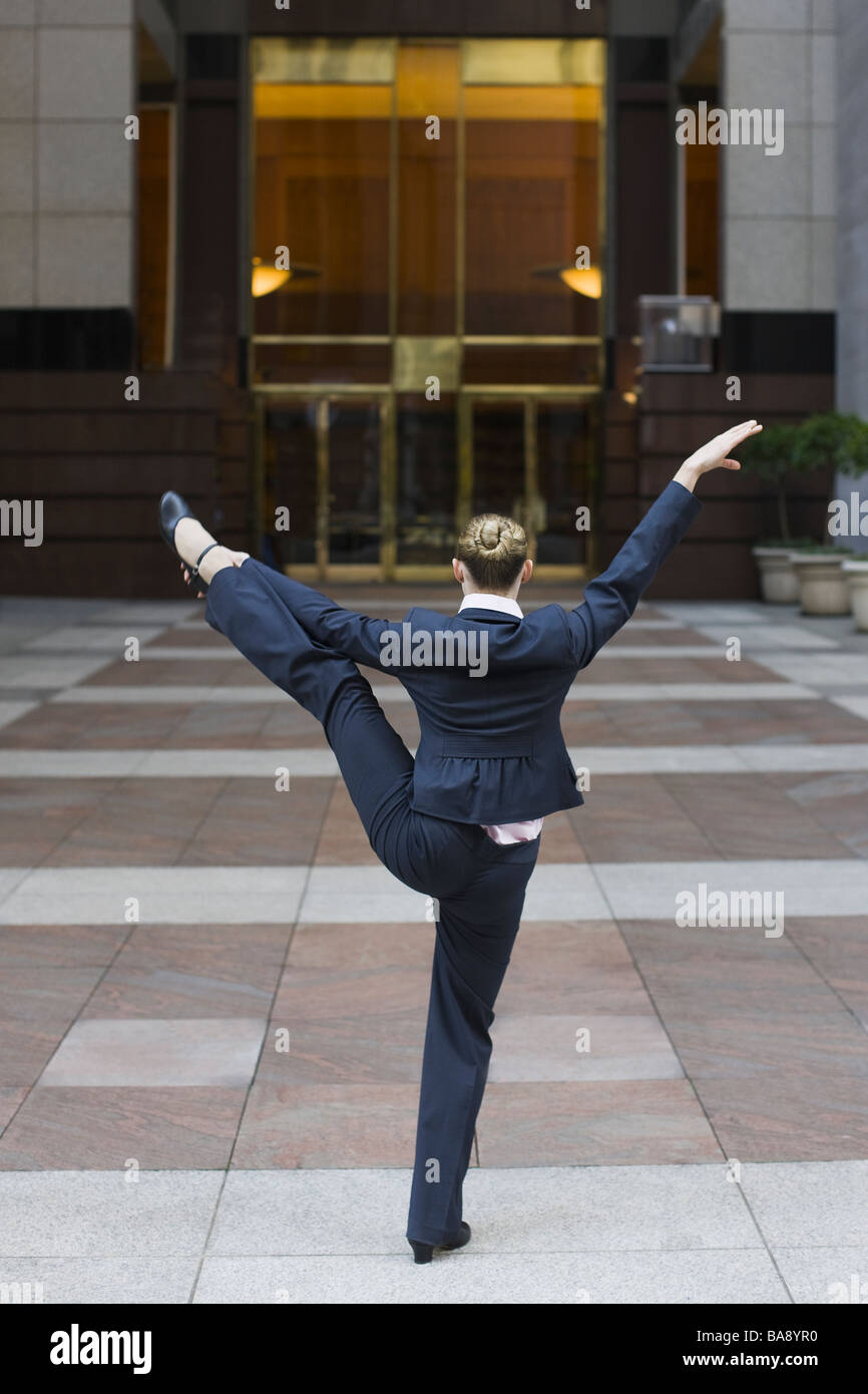 Businesswoman dancing in urban setting Banque D'Images