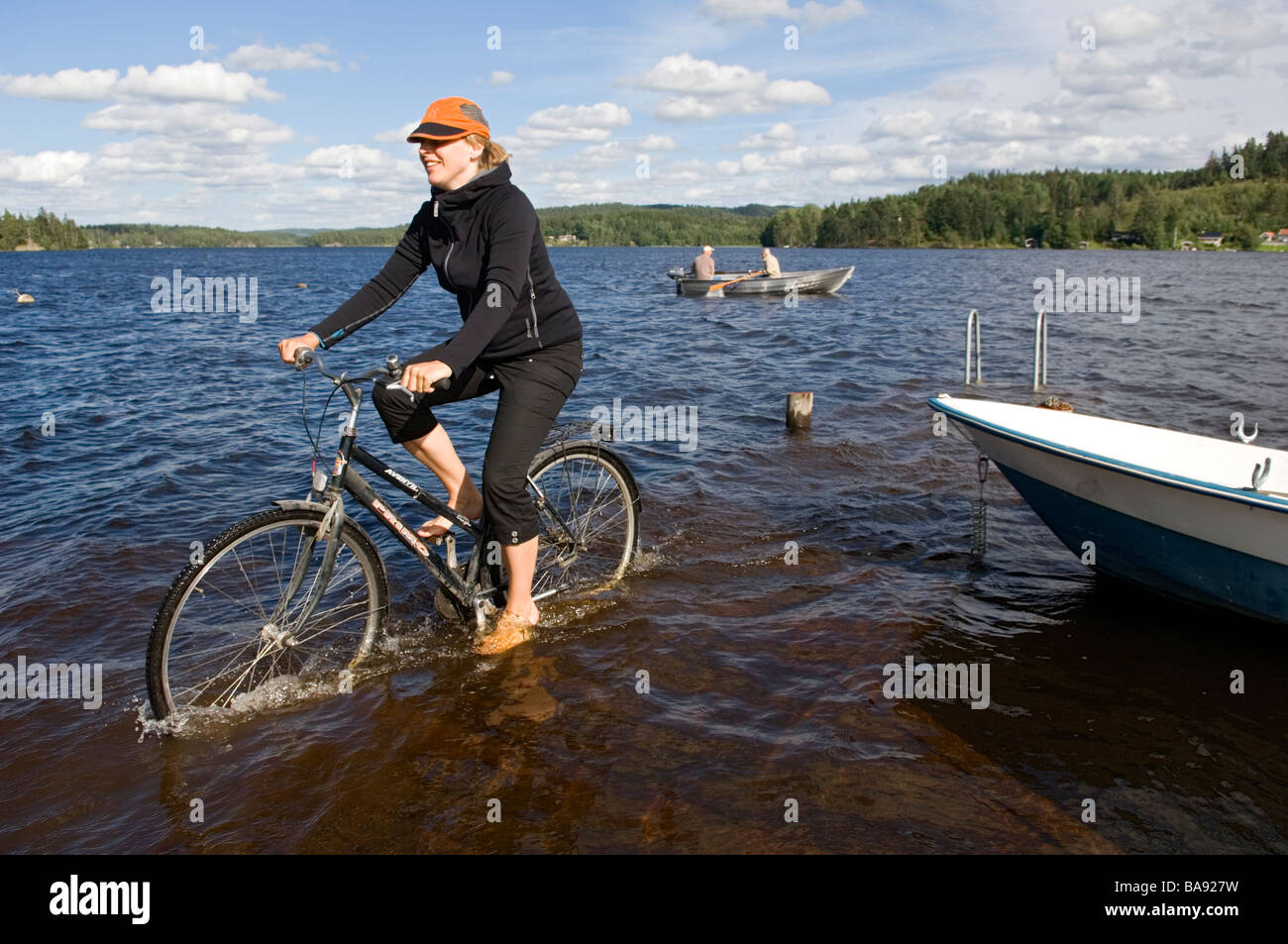 Une femme de faire du vélo dans l'eau de la Suède Banque D'Images