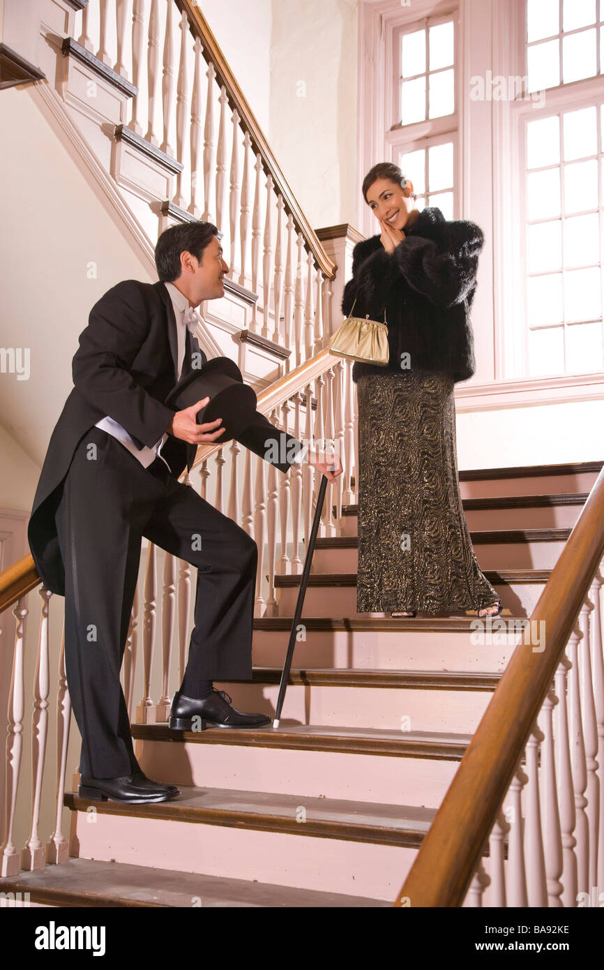 Couple bien habillé dans les escaliers, prêt pour une nuit Banque D'Images
