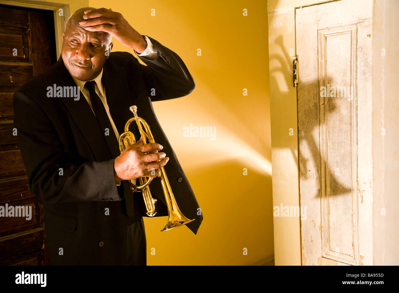 Senior African American musicien de jazz debout dans le couloir avec trompette Banque D'Images