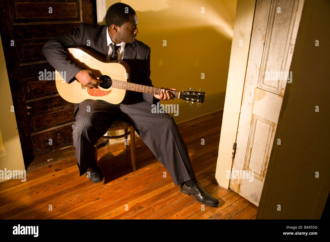 Musicien afro-américain qui joue de la guitare dans le couloir de la chambre Banque D'Images