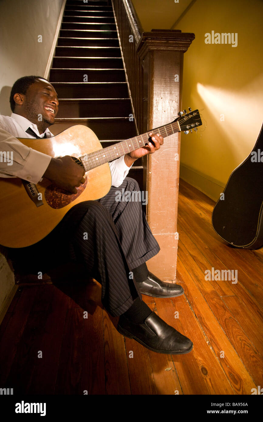 Happy African American musicien qui joue de la guitare dans le couloir de la chambre Banque D'Images