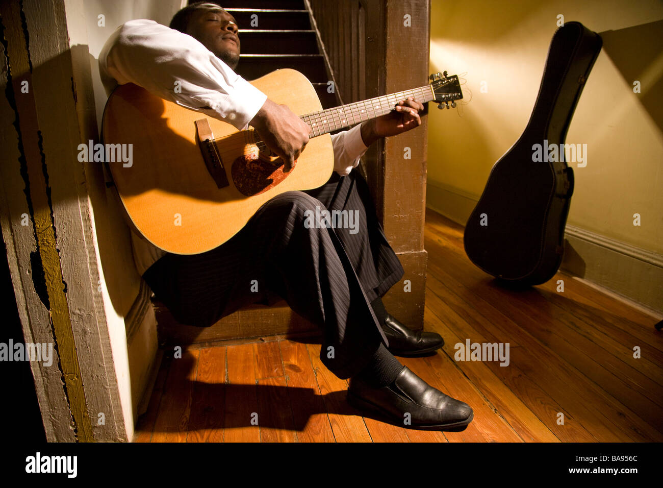 Musicien afro-américain qui joue de la guitare dans le couloir de la chambre Banque D'Images