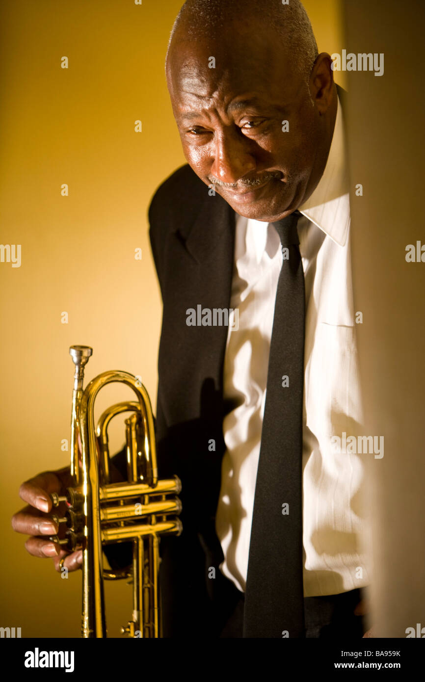 Senior African American musician holding Trumpet in hallway Banque D'Images