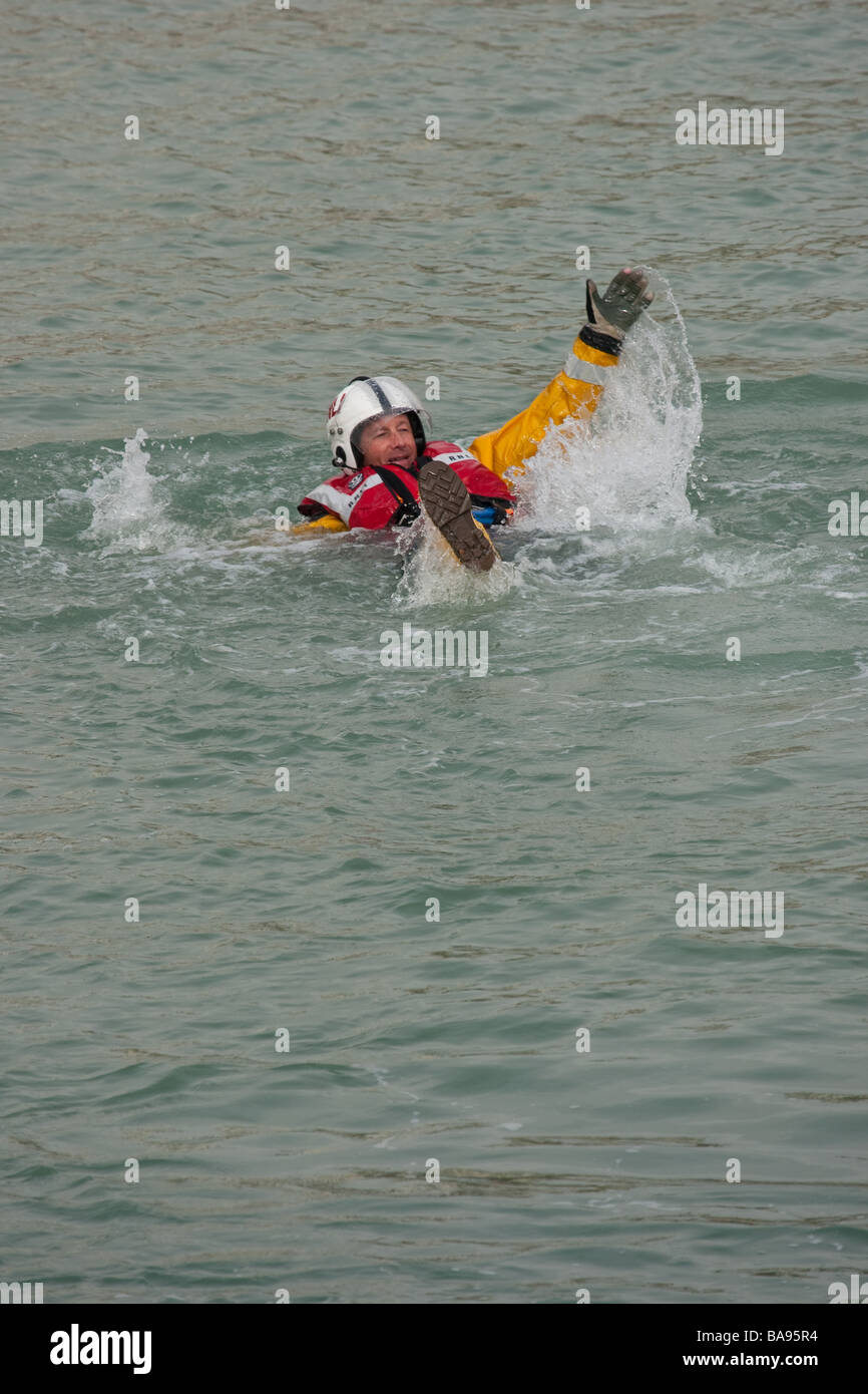 La RNLI (Royal National Lifeboat Institution) membre de l'équipage dans l'eau pendant un exercice d'entraînement. Banque D'Images