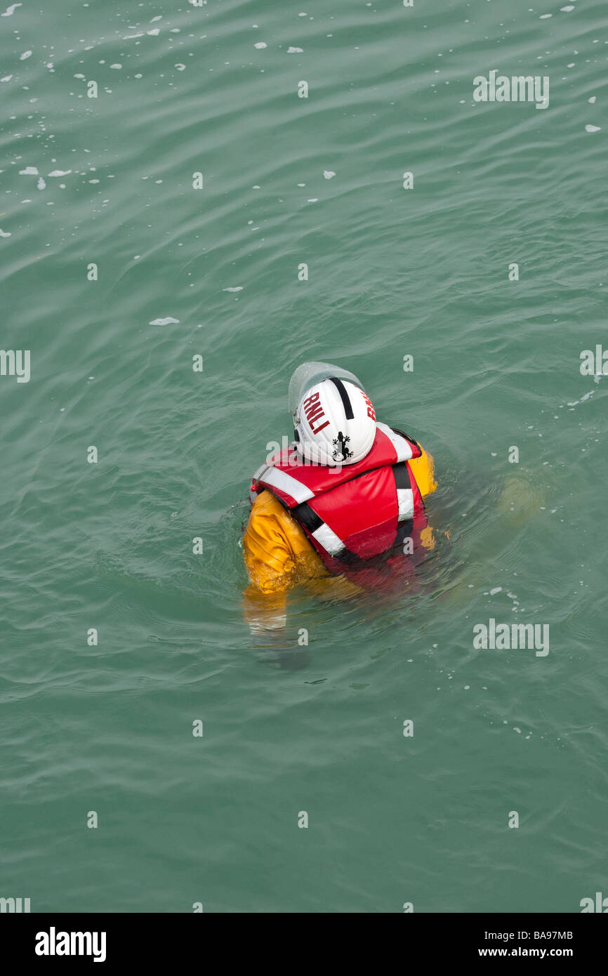La RNLI (Royal National Lifeboat Institution) membre de l'équipage dans l'eau pendant un exercice d'entraînement. Banque D'Images