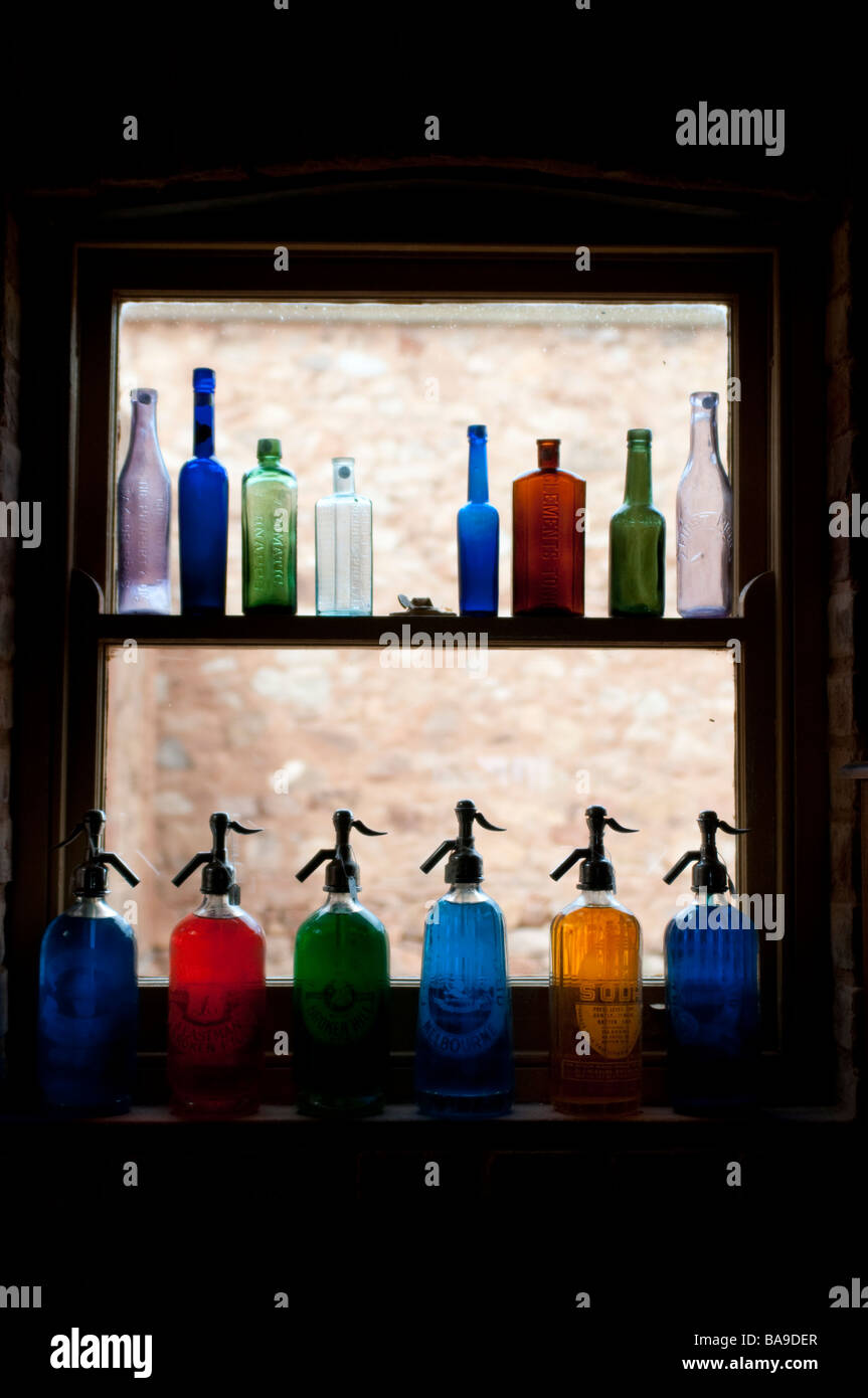 Bouteilles colorées sur un rebord de fenêtre Banque D'Images