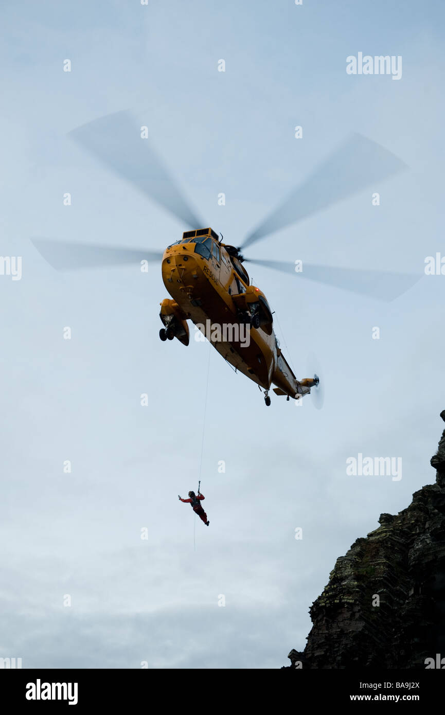 Un hélicoptère Sea King de la RAF Valley le sauvetage d'un jeune homme qui avait perdu sa place sur les falaises à l'ouest du pays de Galles Aberystwyth UK Banque D'Images